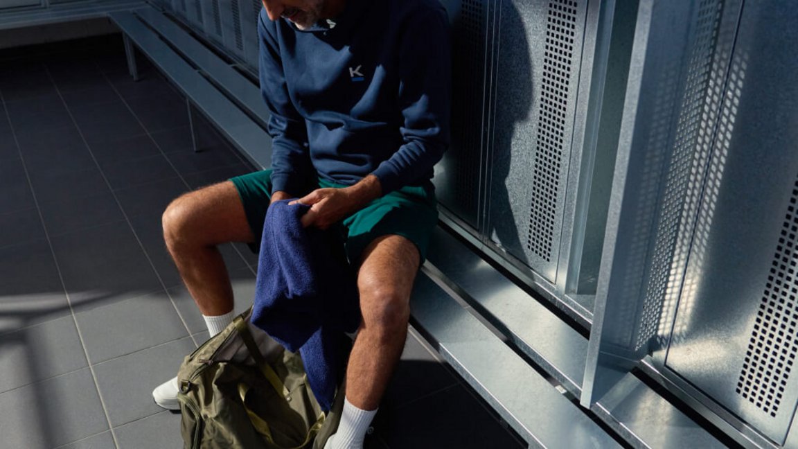 Ein Mann bereitet sich in der modernen und sauberen Umkleide von Kieser auf sein anstehendes Krafttraining vor.