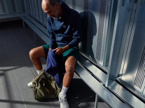 Ein Mann bereitet sich in der modernen und sauberen Umkleide von Kieser auf sein anstehendes Krafttraining vor.