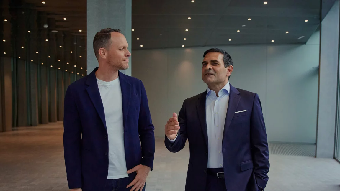 Zwei professionelle Partner im Gespräch über die Kieser Franchise Partnerschaft in einer modernen Business-Umgebung.