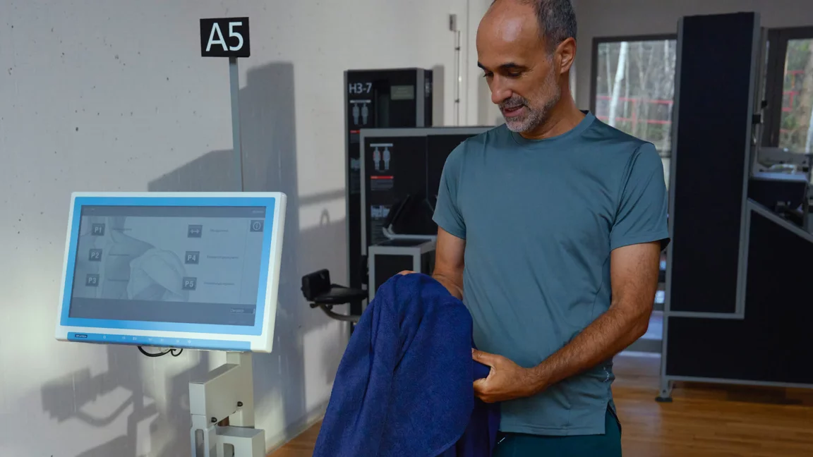 Ein Mann bei Kieser erhält eine professionelle Einweisung in das Beckenboden-Training an der A5-Maschine mit digitalem Biofeedback.